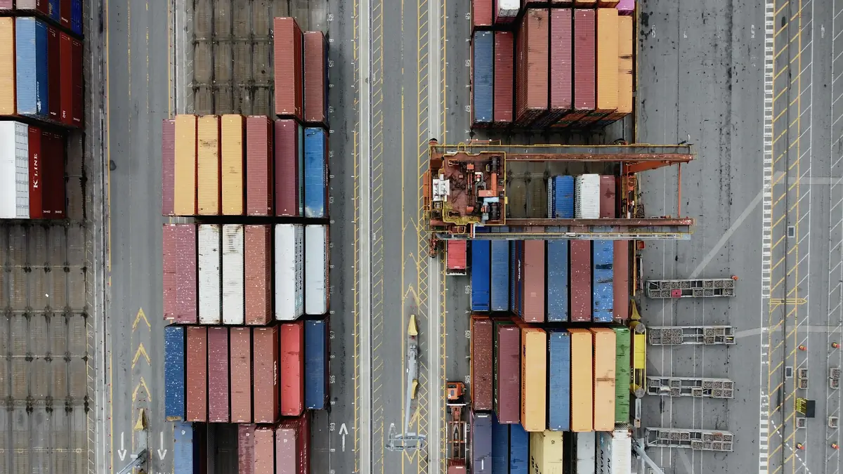 Aerial view of rows of stacked shipping containers at a port