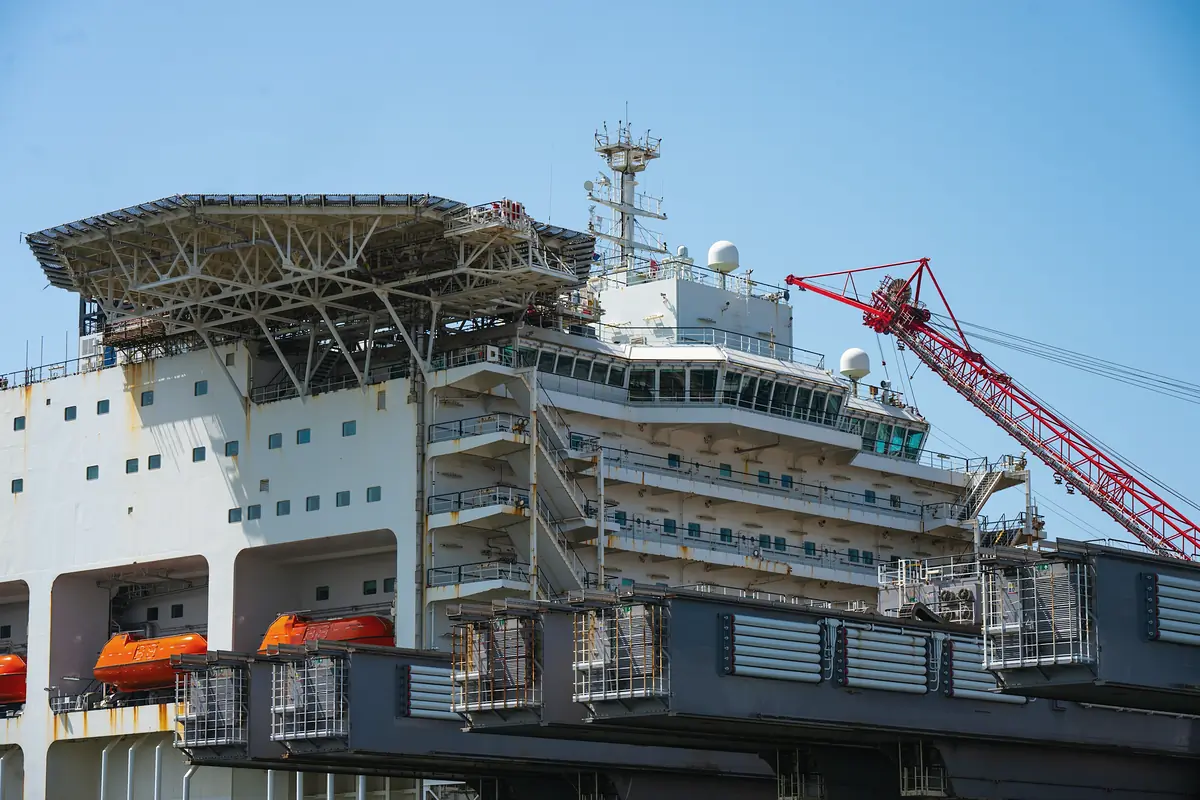 An offshore construction vessel with a helideck and a large crane