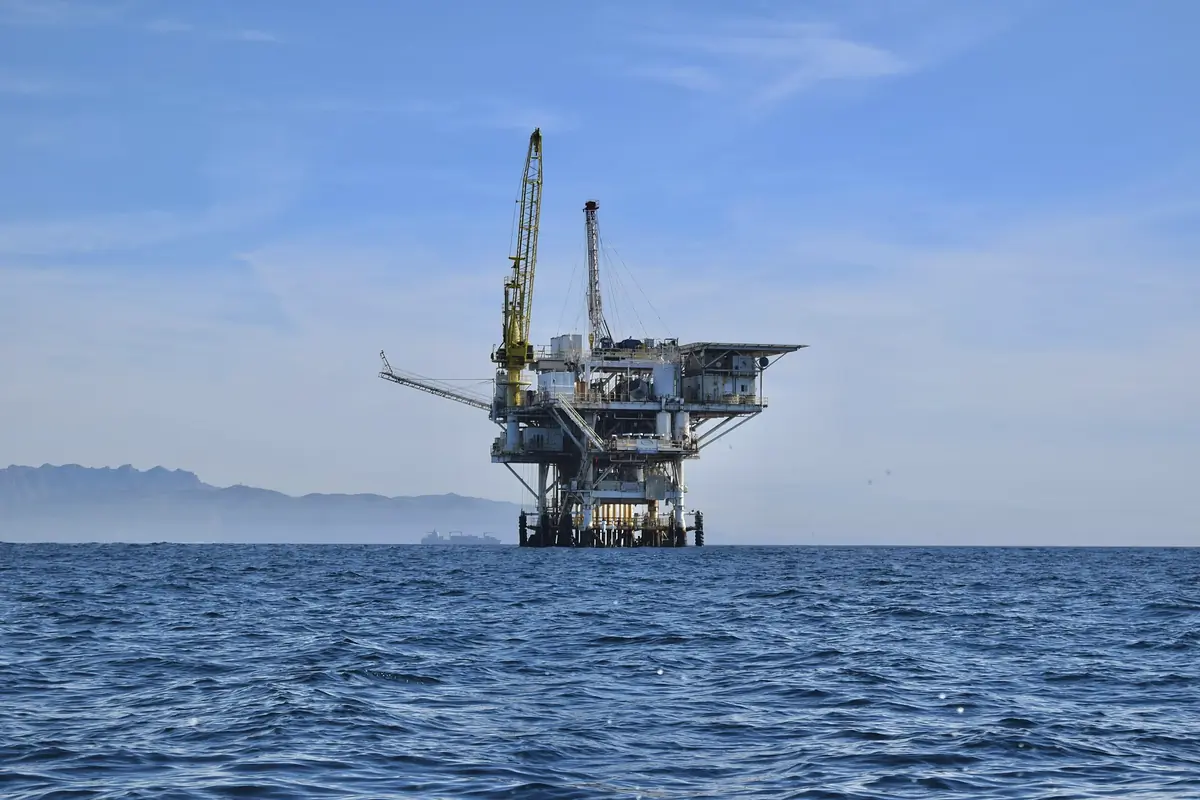 An offshore oil platform standing in open water under a clear sky