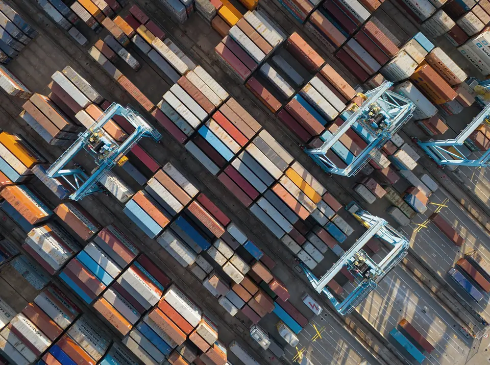 Aerial view of stacked containers and gantry cranes at a container terminal