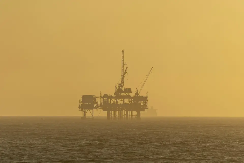 An offshore platform in golden haze on a calm sea